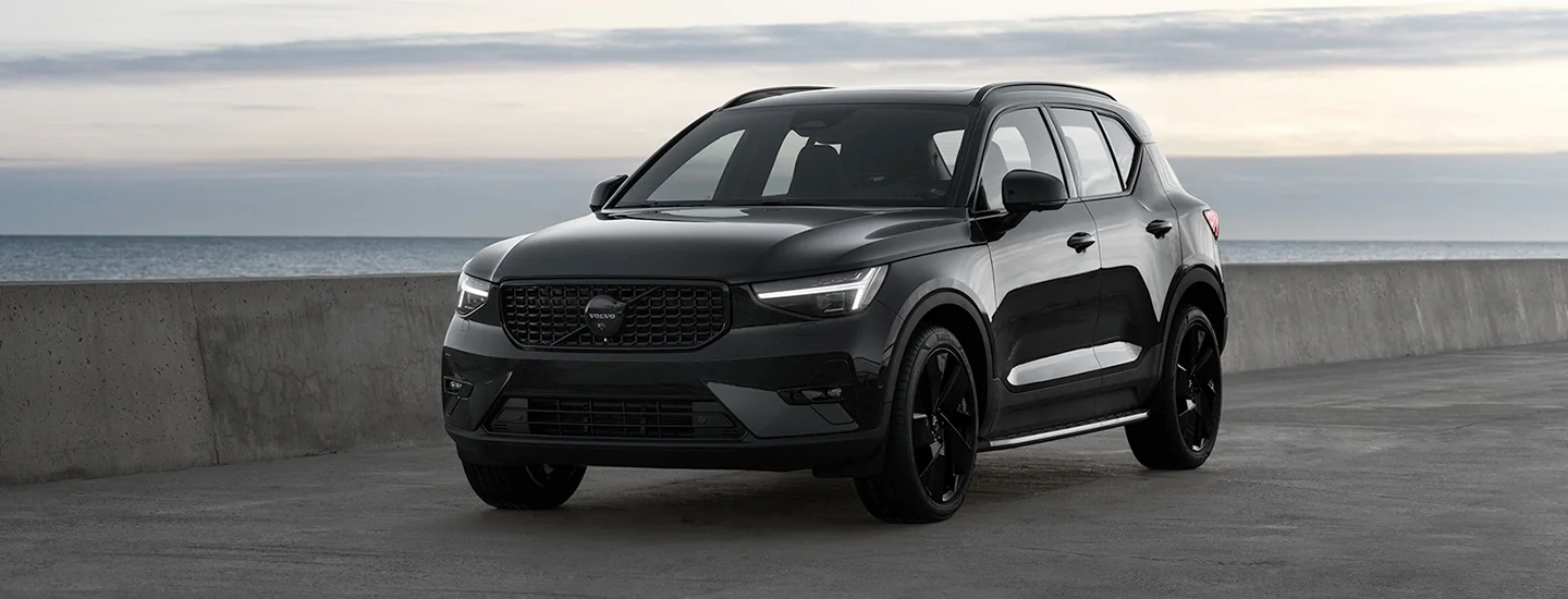 Black 2025 Volvo XC40 parked with water in the background