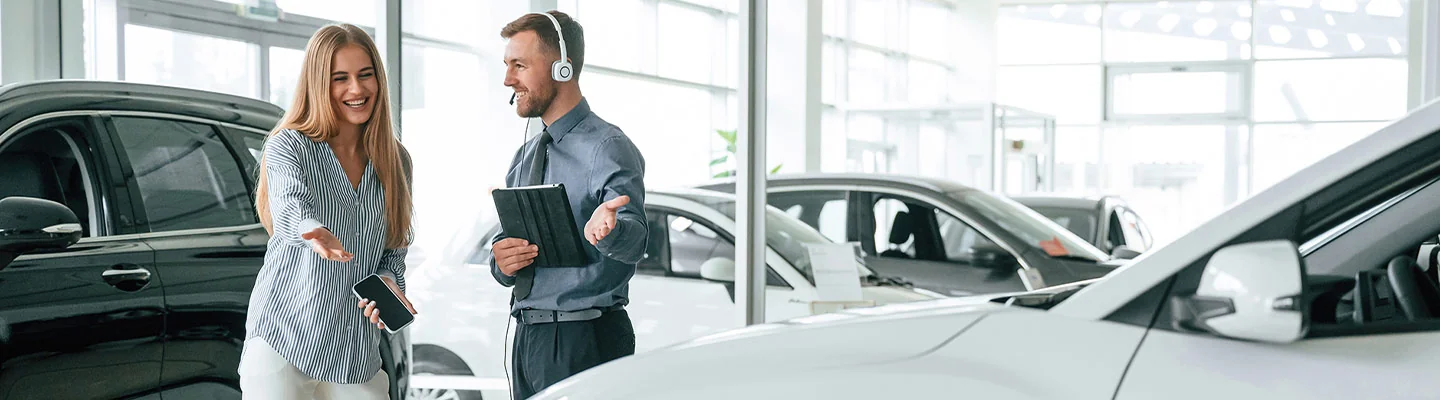 sales person showing a customer a new car