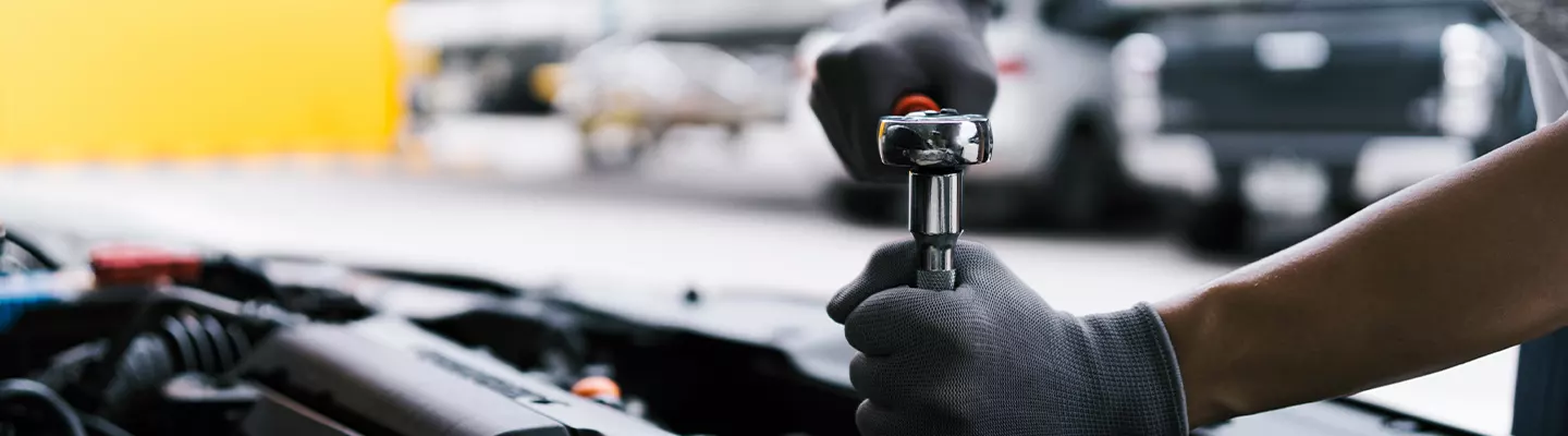 mechanic working under the hood of a vehicle