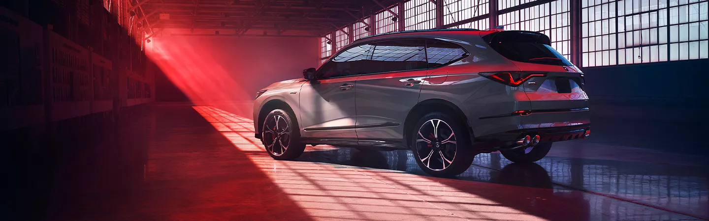 2026 Acura MDX parked in a warehouse with red lighting in the background