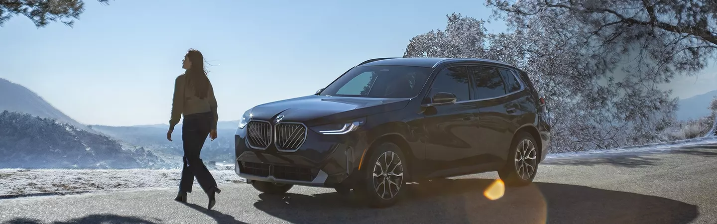 2026 BMW X3 30 parked in front of a mountain overlook with snow in the background