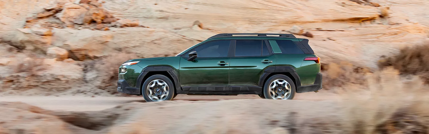 Side view of a 2026 Subaru Outback driving through the desert mountains