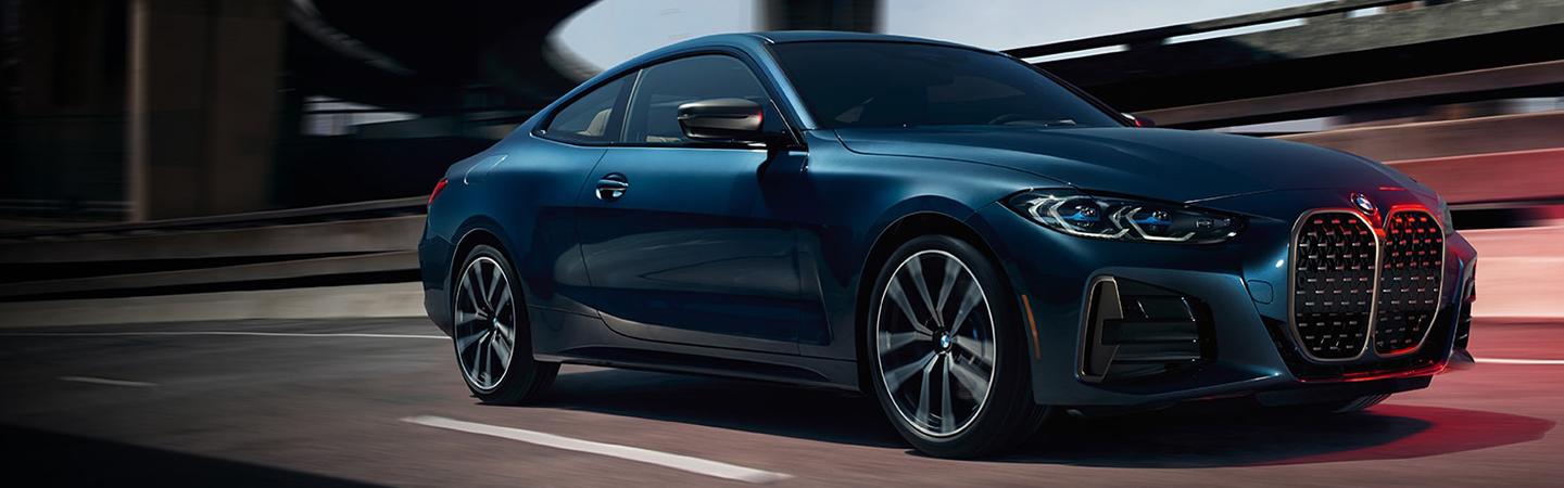 Blue BMW 4 Series parked on the docks