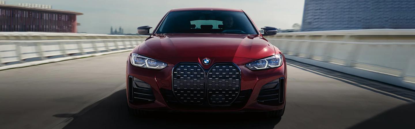Front view of a red BMW 4 Series driving on the road