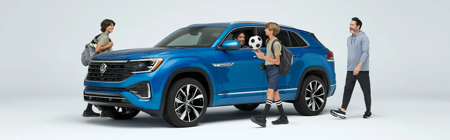 3 persons approaching a and one driver in the 2025 Volkswagen Atlas Cross Sport SE