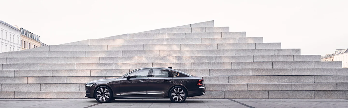 black 2025 Volvo S90 Plug-in Hybrid parked with stairs