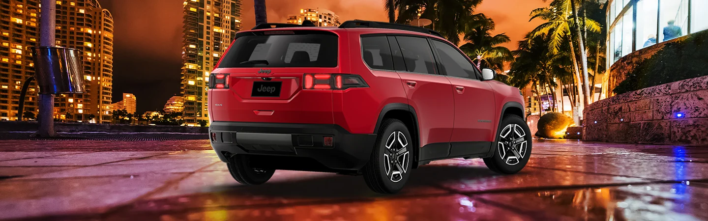 Back side view of a red parked 2026 Jeep Cherokee in the city