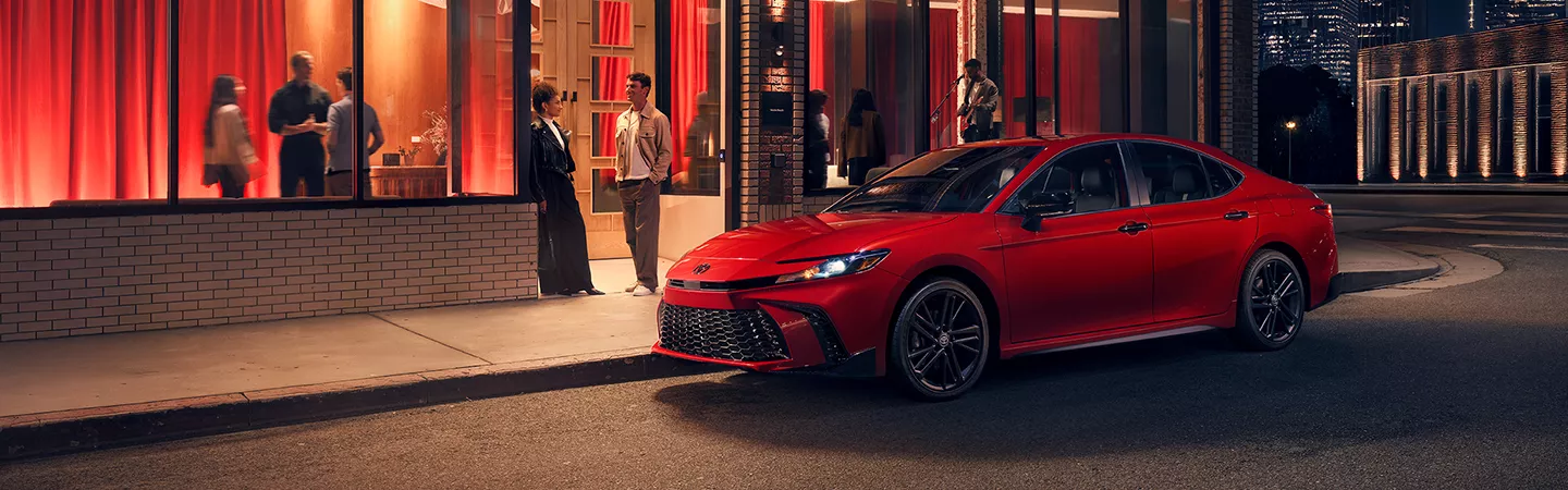 2026 Toyota Camry parked outside a restaurant at night in the city