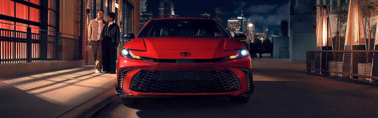 2026 Toyota Camry parked outside a restaurant at night in the city