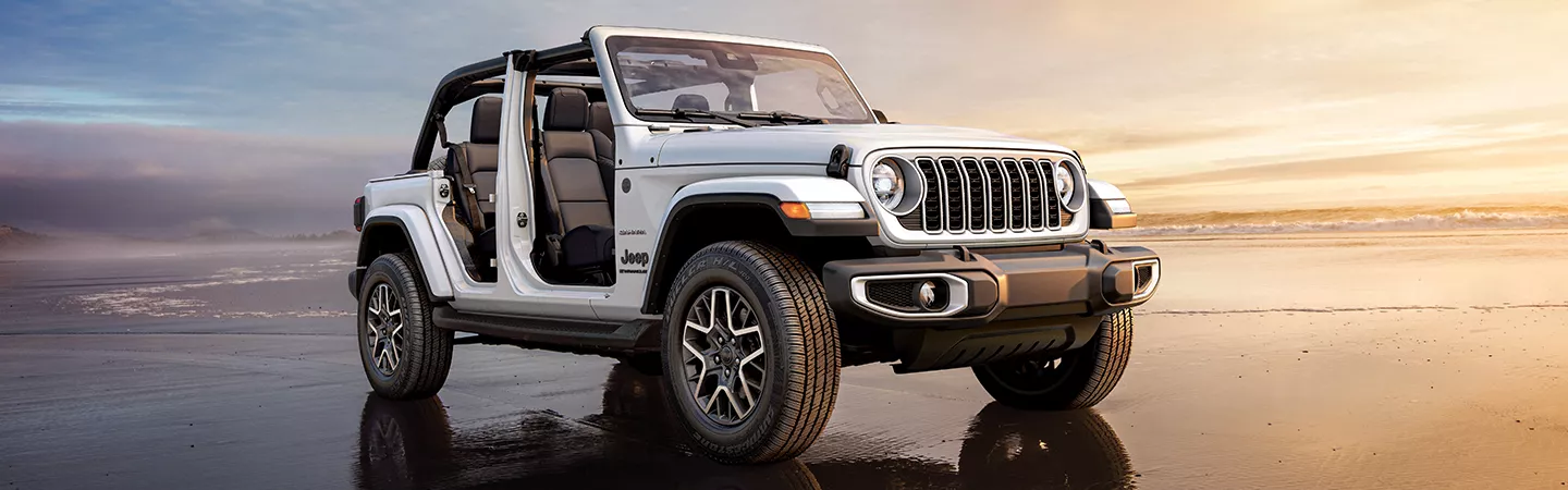 2026 Jeep Wrangler parked on the beach at sunset