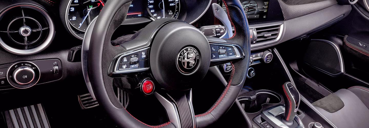 Close-up of a 2021 Alfa Romeo Giulia steering wheel and dash.