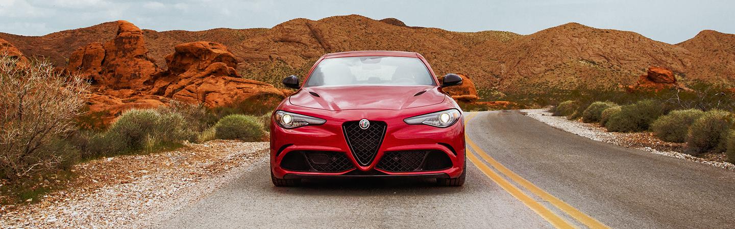 Front view of a red 2021 Alfa Romeo Giulia parked in the desert.