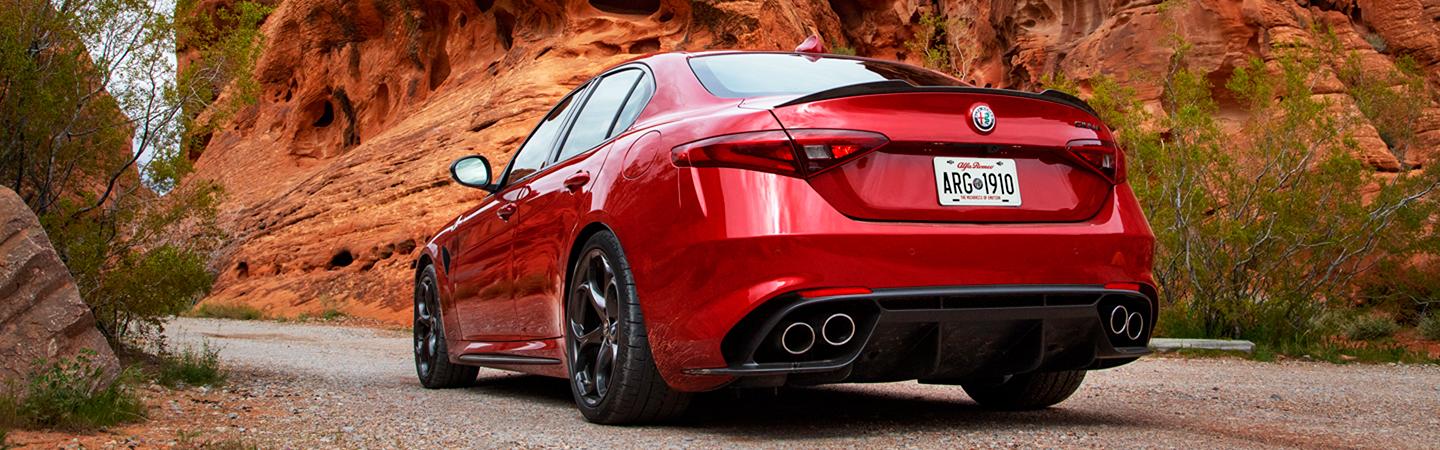 Rear view of a red 2021 Alfa Romeo Giulia parked in the desert.