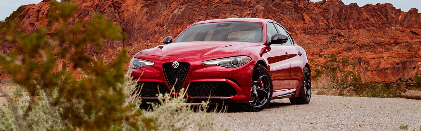 Front view of a red 2021 Alfa Romeo Giulia parked in the desert.