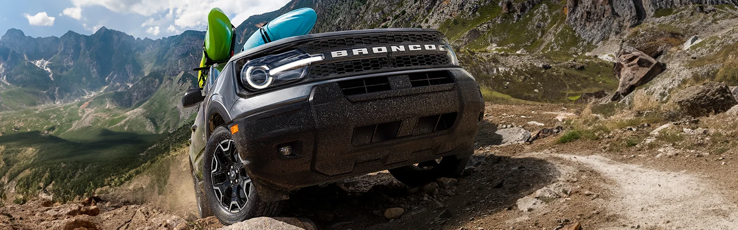 2025 Ford Bronco Base climbing a hill with kayaks strapped on top
