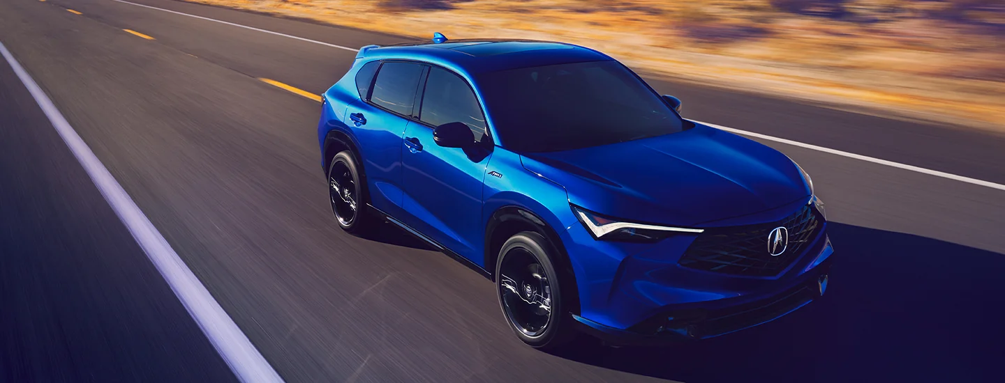 A blue 2025 Acura ADX driving on a road