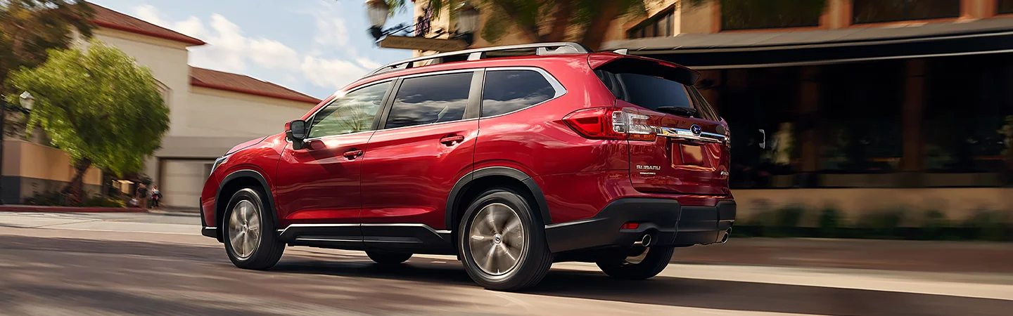 Side view of a red 2025 Subaru Ascent driving on a city street in Chattanooga, TN