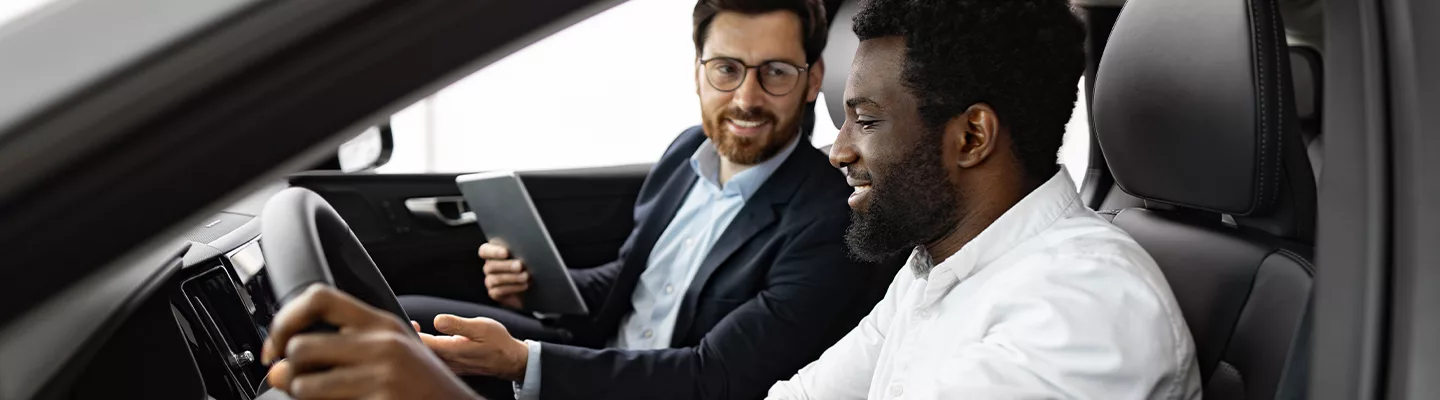 salesman and customer inside of a vehicle talking