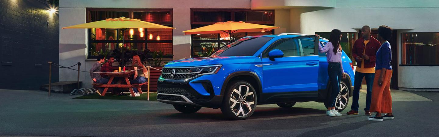 Blue 2022 Volkswagen Taos parked in fornt of a store