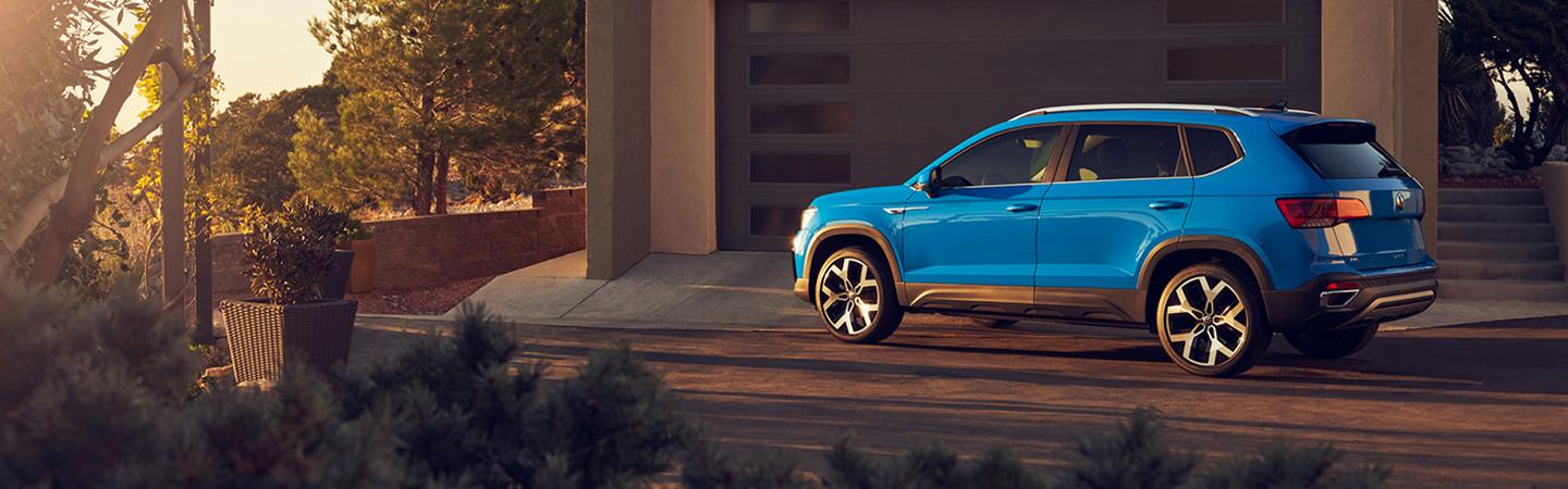 Blue 2022 Volkswagen Taos parked in front of a house