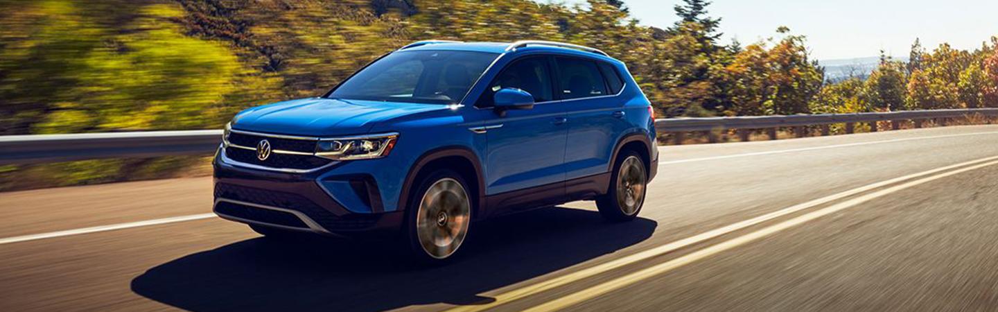 A blue 2022 Volkswagen Taos dring on the road