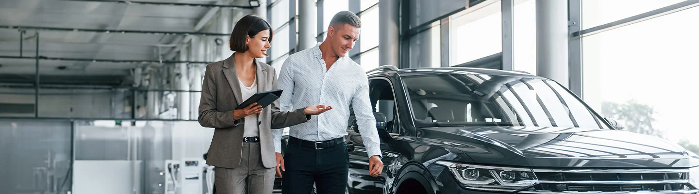Sales person showing customer new cars