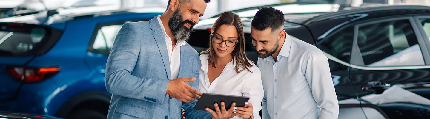 Car salesperson showing information to customers at a BMW dealership