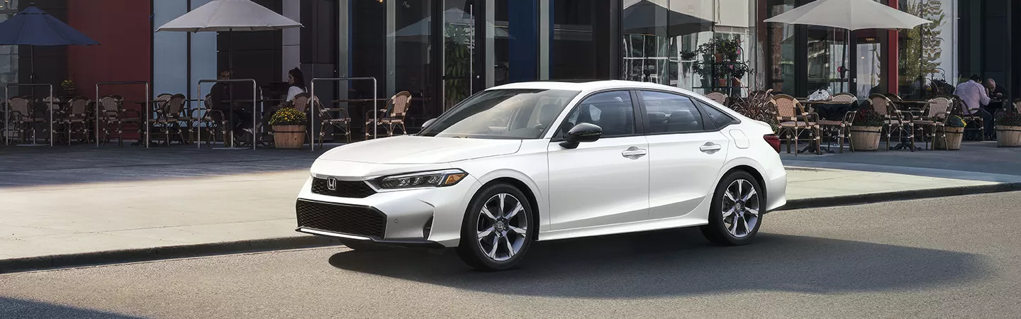 2026 Honda Civic Sedan parked in front of a cafe in the city during the day