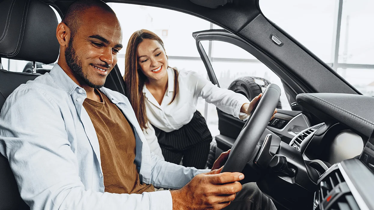 Sales person showing customer the inside of a new car