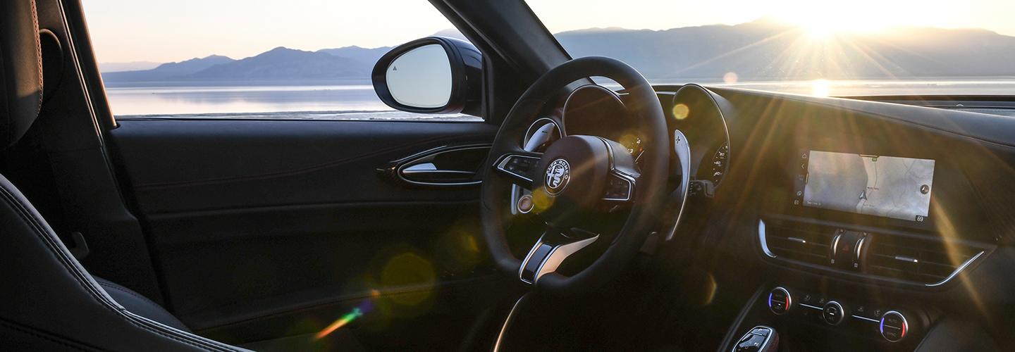 Passenger-side view of the 2021 Alfa Romeo Giulia Quadrifoglio steering wheel and infotainment system.