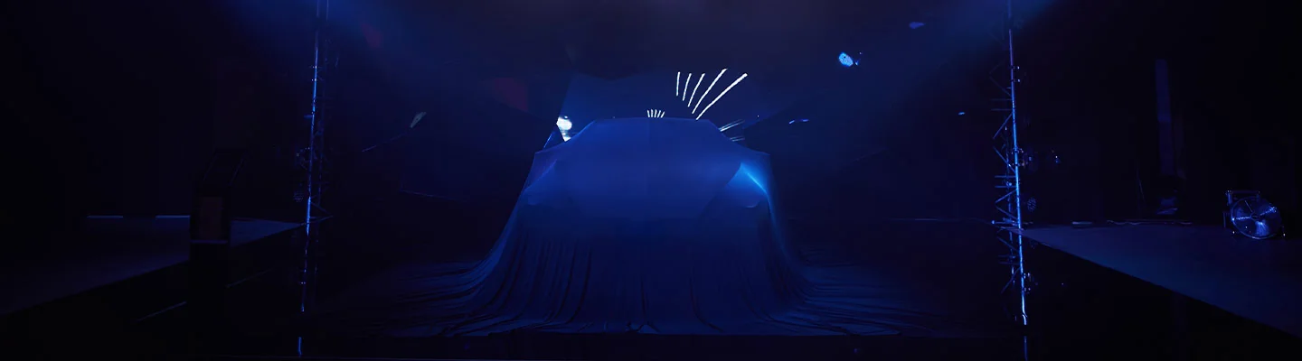 a car covered in a blue cover under a spotlight