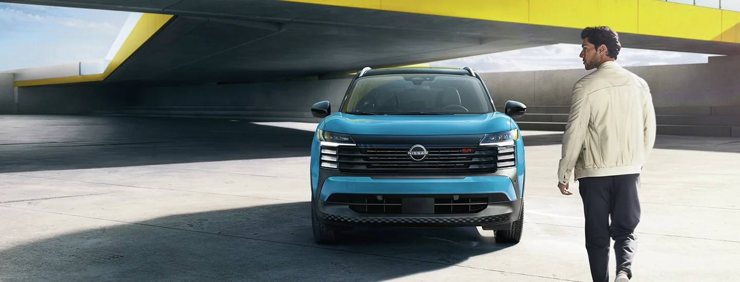 front view of a light blue 2026 Nissan Kicks about to be boared by driver