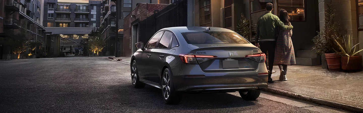 A couple standing next to a 2026 Honda Civic