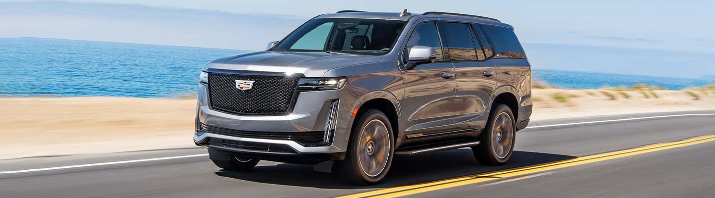 A tan 2021 Escalade in motion near the beach