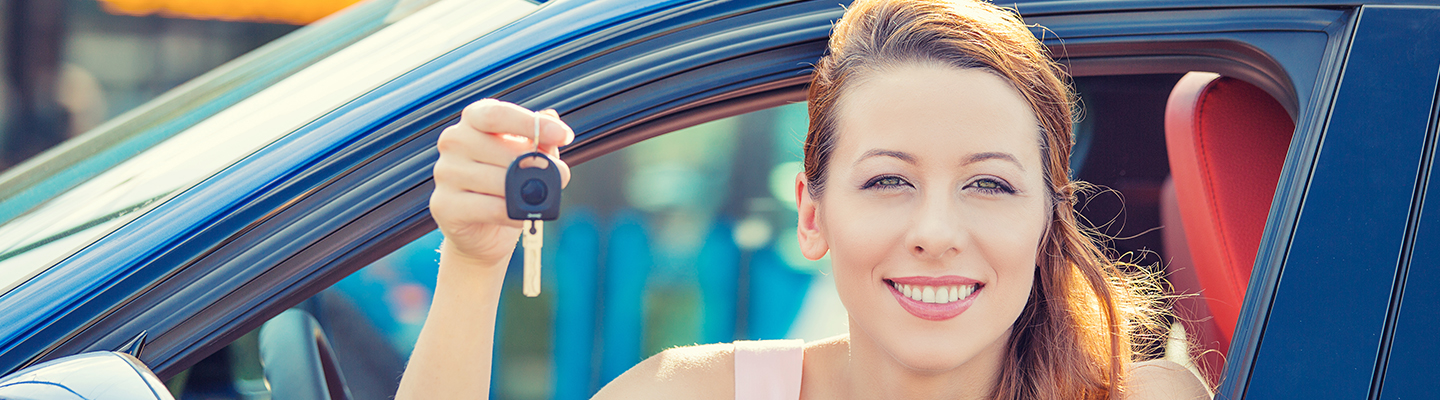  Happy woman holding up keys to her new car