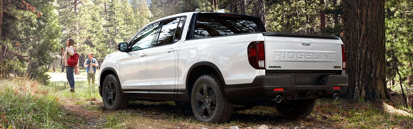 2026 Honda Ridgeline parked at a trailhead with trees in the background
