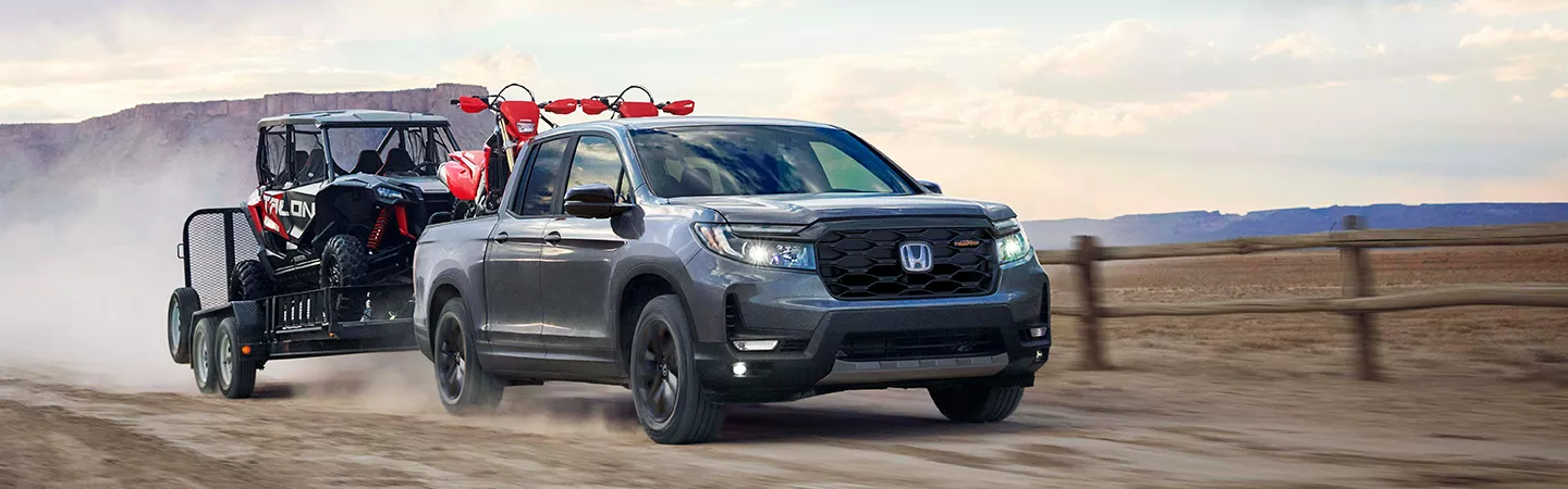 2026 Honda Ridgeline towing all terrain vehicles on a trailer