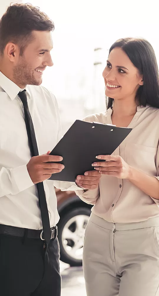Man and woman looking over a clipboard smiling at each other