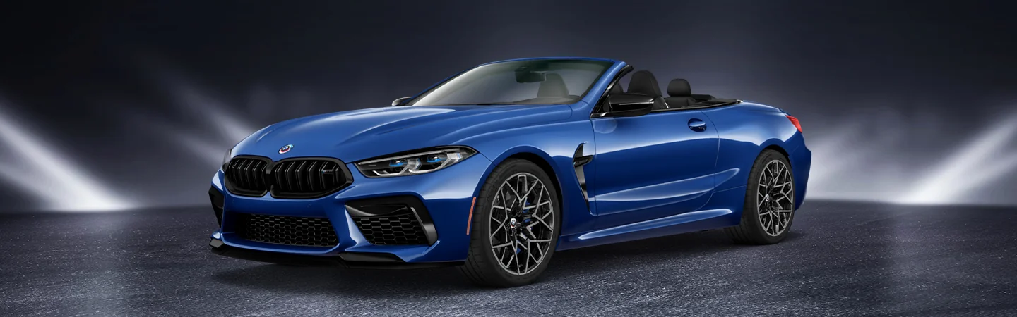 Profile view of a blue 2025 BMW M8 Coupe in a studio