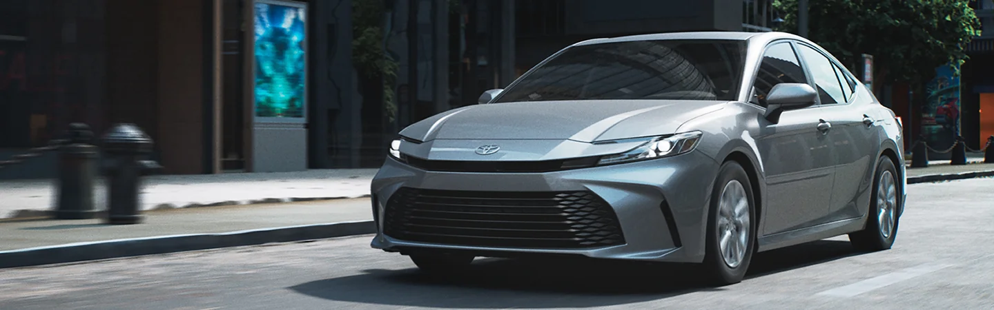 Front view of a gray 2025 Toyota Camry driving in the city