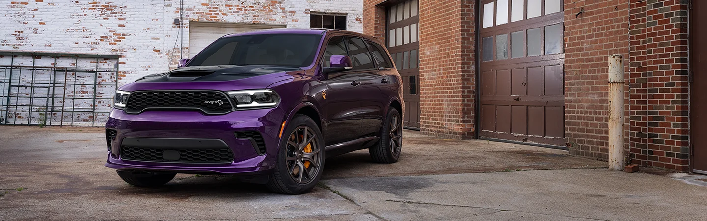 Front view of a purple 2026 Dodge Durango parked by a warehouse