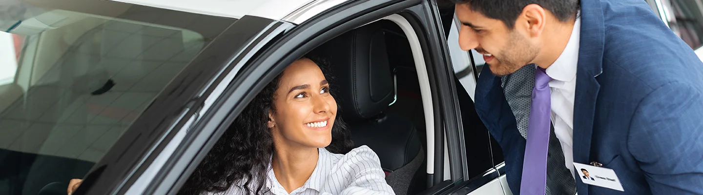 Sales person showing customer a new used car