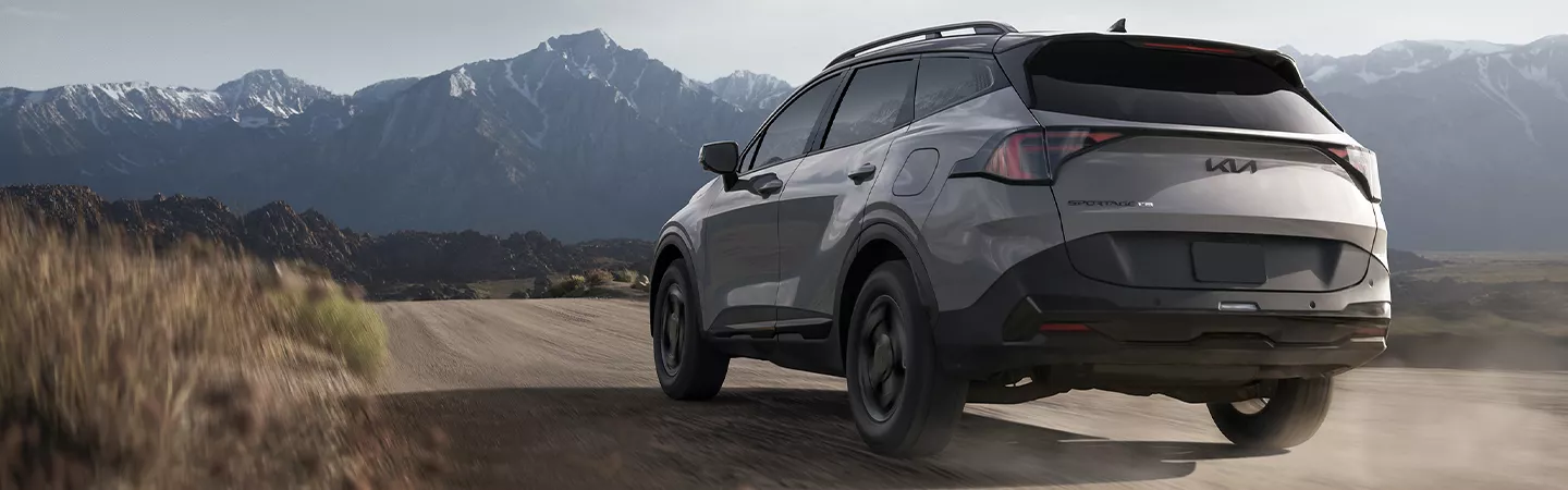 Rear view of 2026 Kia Sportage Hybrid with mountains in the foreground