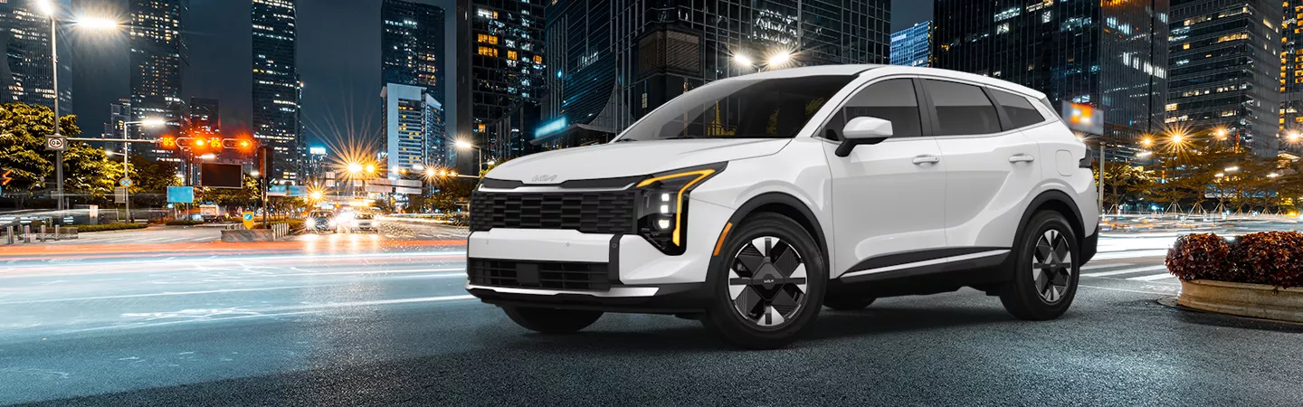 2026 Kia Sportage Hybrid parked in front of a city skyline at night