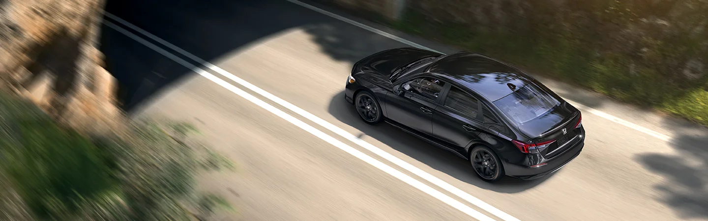 Top view of a black 2026 Honda Civic Hybrid driving on a road