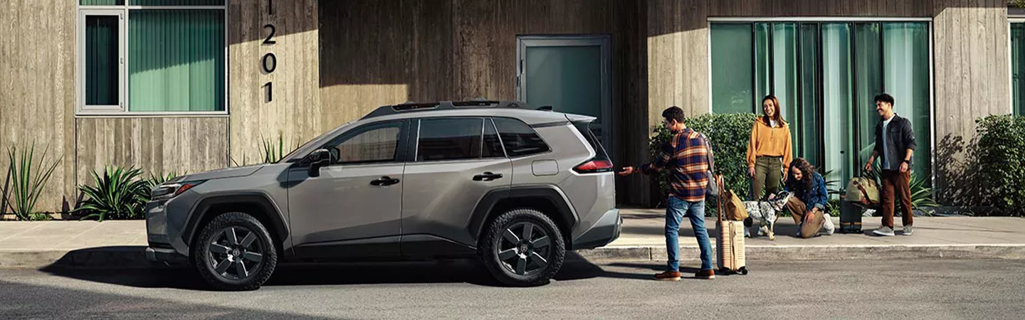 People loading a 2026 Toyota RAV4 with luggage