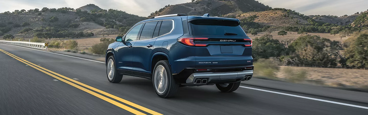 2026 GMC Acadia driving down a road