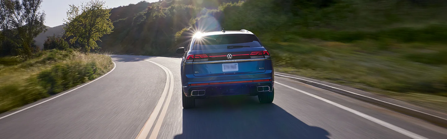 a rear view of an in motion blue 2026 Atlas Cross Sport