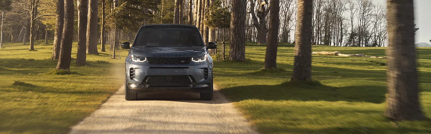 Front view of a 2025 Discovery Sport driving in the woods