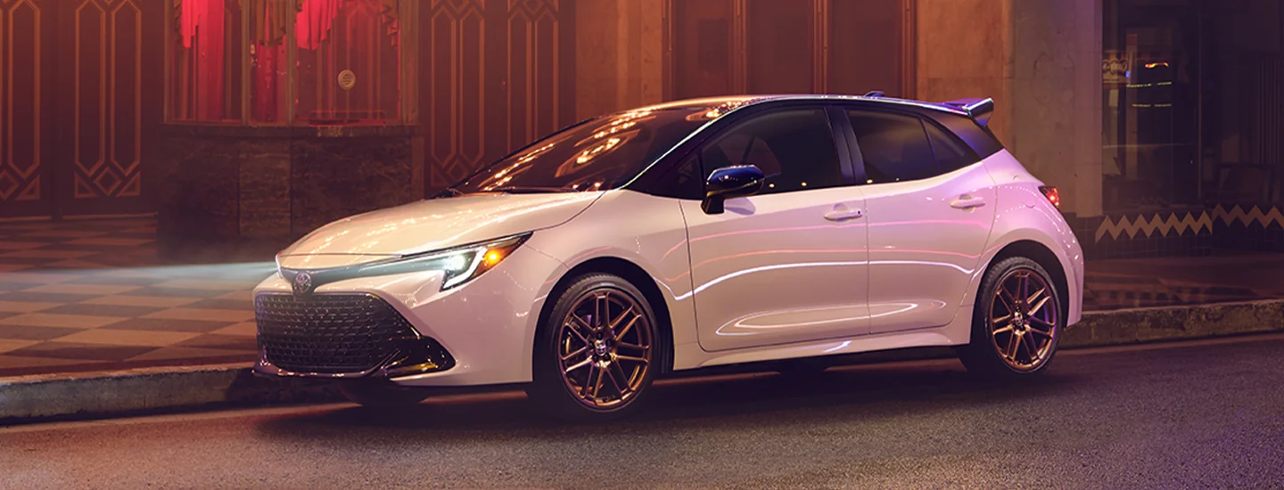 A white 2025 Toyota Corolla Hatchback parked on a city street